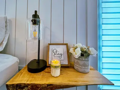 a table with a lamp and a picture and flowers on it at Greenview Retreat in Collingwood