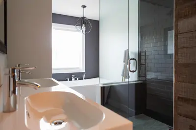 a bathroom with a sink and a tub and a window at Woodland Chase in Wellington