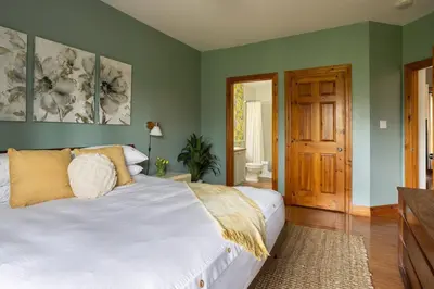 a bedroom with a white bed and green walls at Cosy Chalet - 4 Season Family Oasis in Collingwood