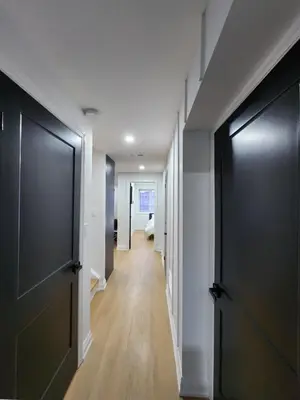 a hallway with black doors and wooden floors at Exclusive Home in Niagara Falls in Thorold