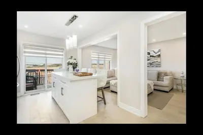 a white kitchen and living room with a view of the ocean at Pristine Pet & Smoke Free 4-Bedroom home near Canada's Wonderland in Vaughan