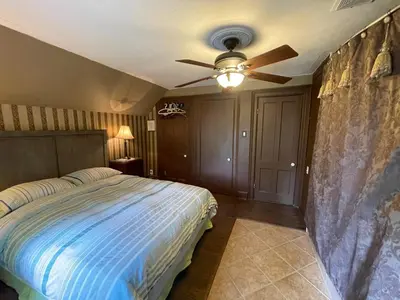 a bedroom with a bed and a ceiling fan at THE RED HOUSE in Niagara Falls