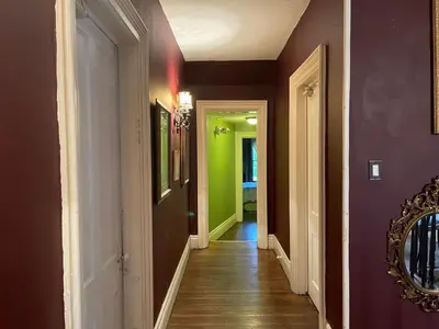 a hallway with green and purple walls and a mirror at THE RED HOUSE in Niagara Falls