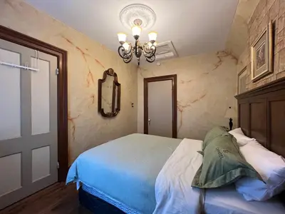 a bedroom with a bed and a chandelier at THE RED HOUSE in Niagara Falls