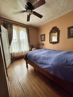 a bedroom with a bed and a ceiling fan at THE RED HOUSE in Niagara Falls