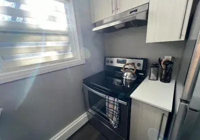 a small kitchen with a stove and a microwave at Rustic Elegance & Style 1BR in London