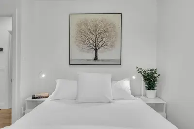 a white bedroom with a tree picture on the wall at Luxury Family Home in Burlington in Burlington