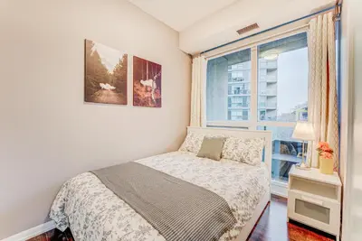 a small bedroom with a bed and a window at Prime City Pad 2 Bedroom with CN Tower View in Toronto
