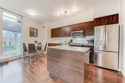 a kitchen with a stainless steel refrigerator and a table at Prime City Pad 2 Bedroom with CN Tower View in Toronto