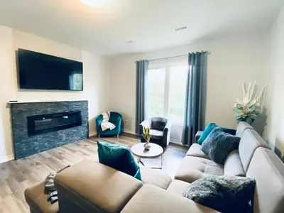 a living room with a couch and a fireplace at Stylish 3 Bdrm house- king bed, Netflix, parking in Kitchener