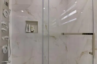 a bathroom with a shower with a glass door at Beautiful House In Scarborough in Toronto