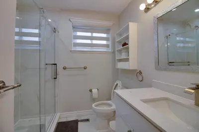 a white bathroom with a sink and a toilet at Beautiful House In Scarborough in Toronto