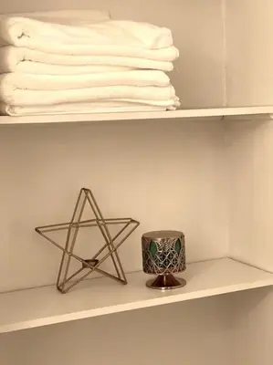 a shelf with a star candle and towels on it at Vintage 2 bed 2 bath suite Distillery District in Toronto