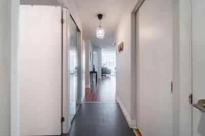 a hallway with white walls and a white door at Spacious 2 Bedroom plus Den, 2 Bath, Sleeps 5 with Balcony and Lakeview Downtown Toronto Condo in Toronto