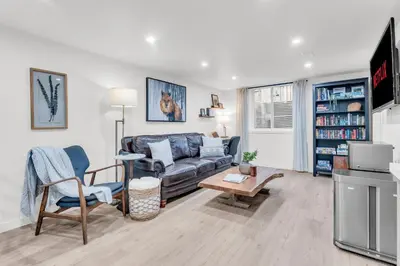 a living room with a couch and a table at Spacious Elegance: Two Living Spaces in One Home in Burlington
