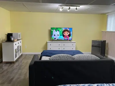 a bedroom with a bed and a tv on a wall at Private Suite in Niagara Falls in Niagara Falls