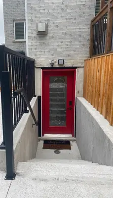 a red door on the side of a building at Brand new apartment with private entrance and patio in Guelph