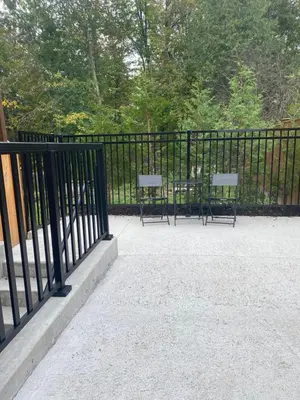 two benches sitting next to a black fence at Brand new apartment with private entrance and patio in Guelph