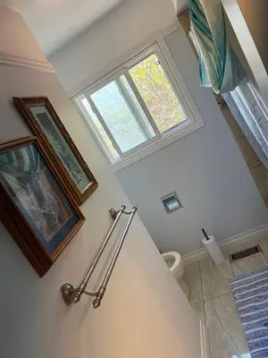 a bathroom with a toilet and a window at Queen’s Gate Ecstasy Home in Brampton
