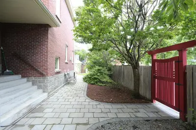 a brick house with a red gate and a fence at Xiao Wang in Toronto