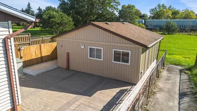 a small shed with a door and a fence at The Garden Retreat in Welland, On - 1BR,Free Parking and Workspace in Welland