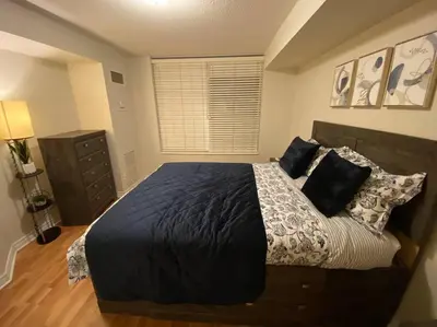 a bedroom with a large bed with black sheets and pillows at Alaa Aldahhan in Mississauga