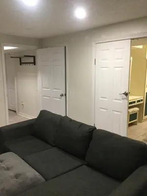 a living room with a couch and two white doors at Lower Unit Entire Apartment in Cambridge