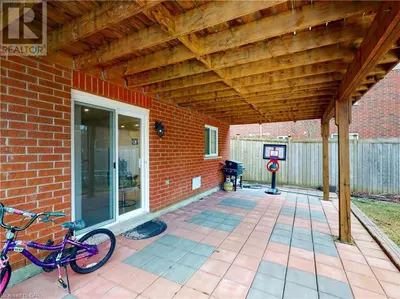 a patio with two bikes parked under a wooden roof at Lower Unit Entire Apartment in Cambridge