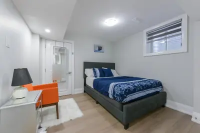 a bedroom with a bed and a desk and a window at 2 Bedroom Private Suite-Parking-Near Hospital and Airport in Oakville