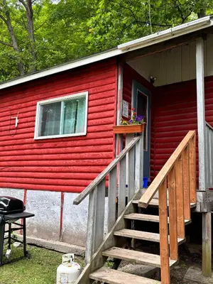 a red house with a staircase leading to the door at Lakefront Hideaway Resort 10 Total cabins-Lake View, Private Beach in Kawartha Lakes