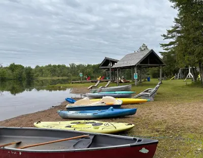 a group of kayaks on the shore of a lake at Lakefront Hideaway Resort 10 Total cabins-Lake View, Private Beach in Kawartha Lakes