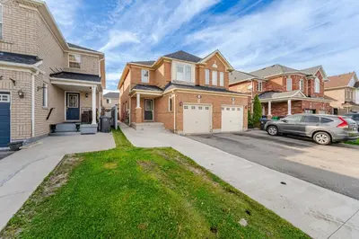 a house with a car parked in a driveway at Lovely Cozy Apartment in Brampton