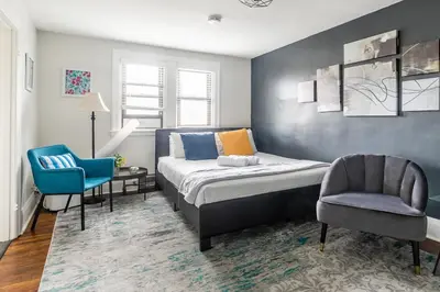 a bedroom with a bed and a chair at Newly Renovated Modern Studio on James St South in Hamilton