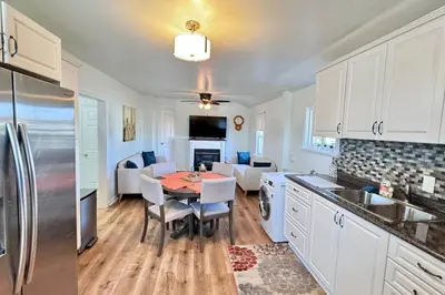 a kitchen with a table and a living room at Near the Falls Two Bedroom - 5 min Walk to Clifton in Niagara Falls