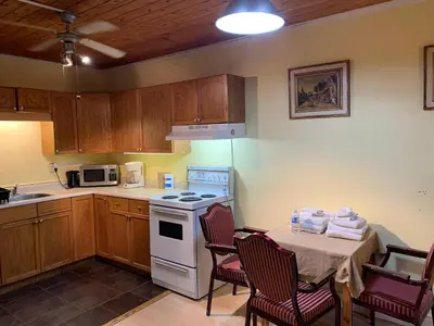 a kitchen with a table and a white stove top oven at Marmora and Lake Inn Apartment-Sleeps 5 guests in Marmora