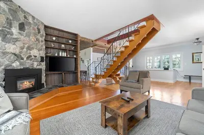 a living room with a fireplace and a stone wall at Golden Field Farmhouse - stayinpec on IG in Bloomfield