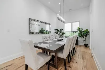 a dining room table with white chairs and a mirror at Comfortable Room in Toronto next to Yorkdale mall in Toronto
