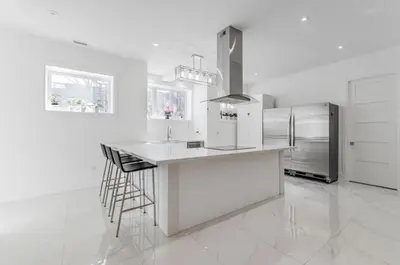 a white kitchen with a counter and a refrigerator at Comfortable Room in Toronto next to Yorkdale mall in Toronto