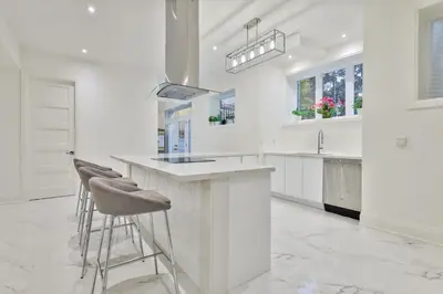 a white kitchen with stools at a counter at Comfortable Room in Toronto next to Yorkdale mall in Toronto