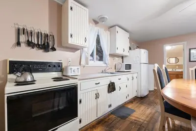 a kitchen with white cabinets and a wooden table with a tableablish at Beautiful Lake Views in Nature in Bailieboro