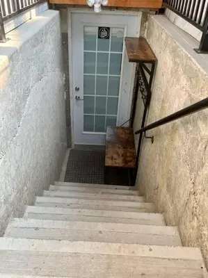 a stairway leading to a door with a bench in front at Brand new single unit guest basement apartment in Mississauga