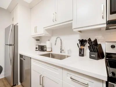 a kitchen with white cabinets and a sink at Cozy Studio Apt - Corktown Hamilton - Near DT in Hamilton