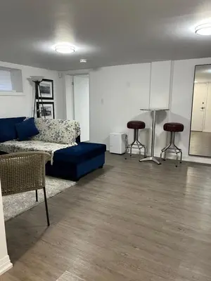 a living room with a couch and two stools at Merritt Place Niagara in St. Catharines