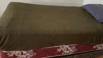 a bed with a brown bedspread with flowers on it at Private Rooms, Free Parking, Full Kitchen, Best Prices in Town- York University Heights in Toronto