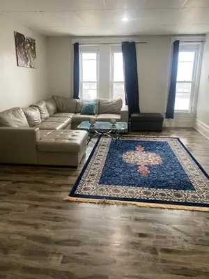a living room with a couch and a rug at Downtown Apartment 6-7 people in Bowmanville