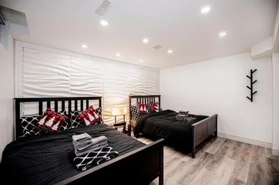 a bedroom with two beds and a white wall at Luxury 2BR Guest Suite in Vaughan