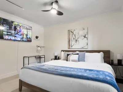 a bedroom with a large bed with a ceiling fan at Hot Tub Haven in Toronto