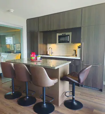 a kitchen with a counter and two bar stools at Elegant 2BR & 2BA Retreat in Prime Yorkville, Downtown in Toronto