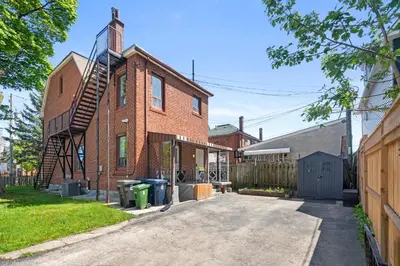 an old brick building with a spiral staircase on it at Stylish & Inviting Private Bedroom in Corso Italia in Toronto