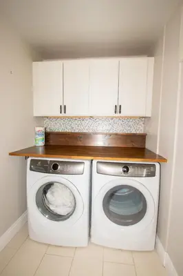 a washer and dryer in a kitchen with white cabinets at Deer Run Cottage- Golf Course cottage in Kawartha Lakes